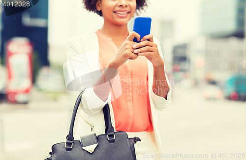 Image of close up of african woman with smartphone in city