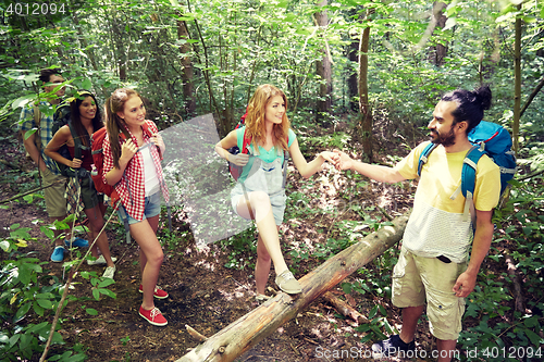 Image of group of smiling friends with backpacks hiking