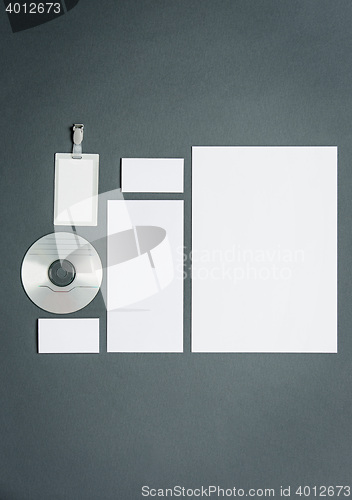 Image of Mock-up business template with cards, papers, disk. Gray background.