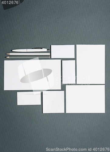 Image of Mock-up business template with cards, papers, pen. Gray background.