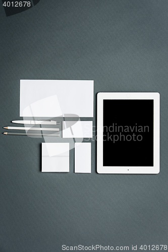 Image of Mock-up business template with cards, papers, tablet. Gray background.