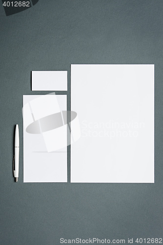 Image of Mock-up business template with cards, papers, pen. Gray background.