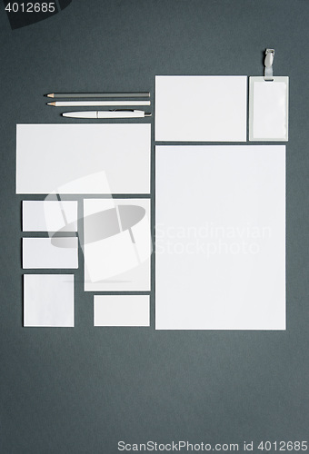 Image of Mock-up business template with cards, papers, pen. Gray background.