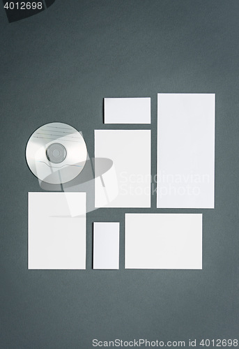 Image of Mock-up business template with cards, papers, disk. Gray background.