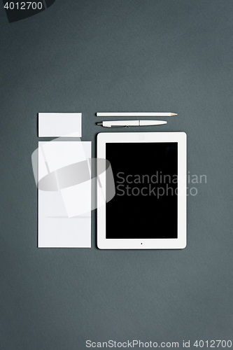 Image of Mock-up business template with cards, papers, tablet. Gray background.