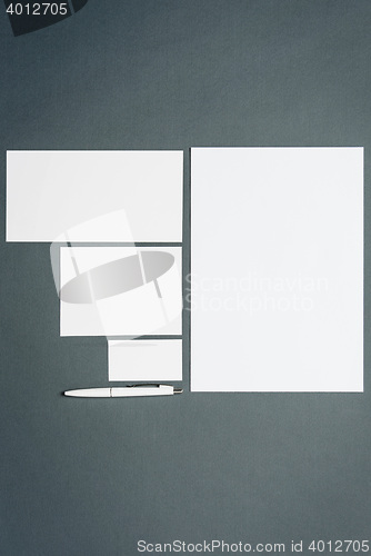 Image of Mock-up business template with cards, papers, pen. Gray background.