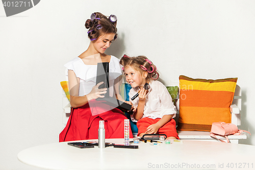 Image of Little girl playing with her mom\'s makeup