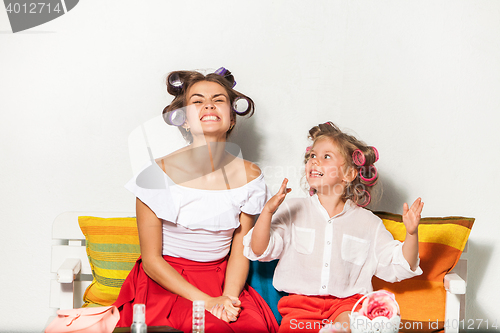 Image of Little girl sitting with her mother and playing