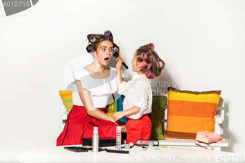 Image of Little girl playing with her mom\'s makeup