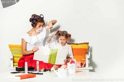 Image of Little girl sitting with her mother and looking at a photo album