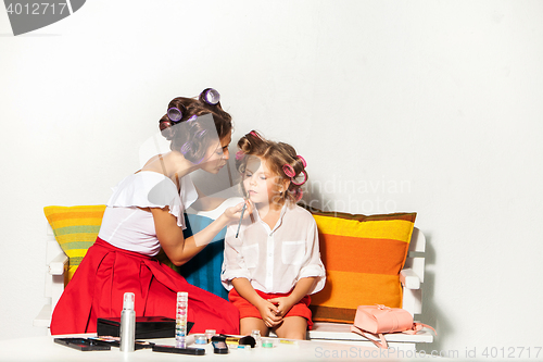 Image of Little girl playing with her mom\'s makeup