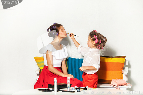 Image of Little girl playing with her mom\'s makeup