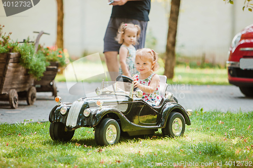 Image of The little baby girl playing at car