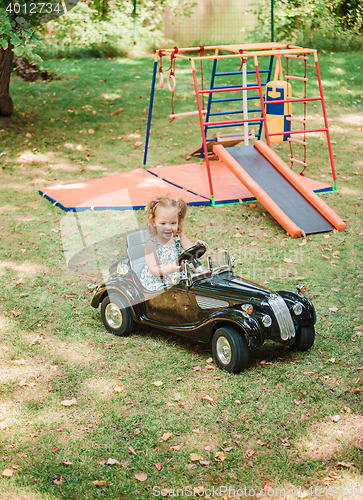 Image of The little baby girl playing at car