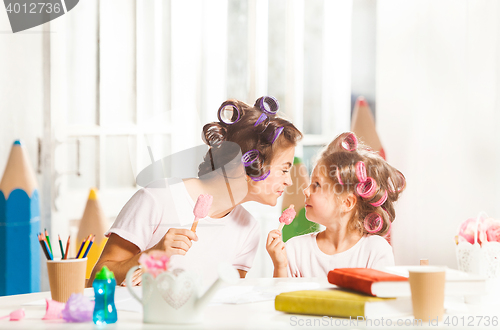 Image of Little girl sitting with her mother and eating ice cream