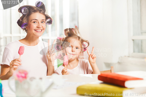 Image of Little girl sitting with her mother and eating ice cream
