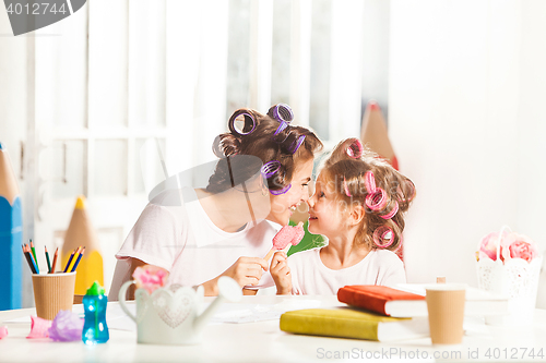 Image of Little girl sitting with her mother and eating ice cream