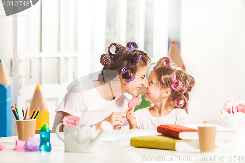 Image of Little girl sitting with her mother and eating ice cream
