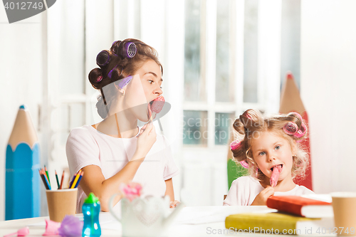 Image of Little girl sitting with her mother and eating ice cream