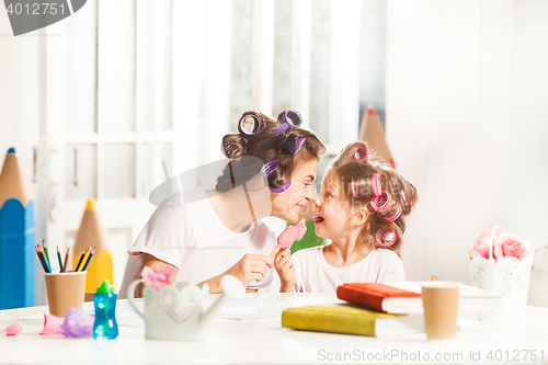 Image of Little girl sitting with her mother and eating ice cream