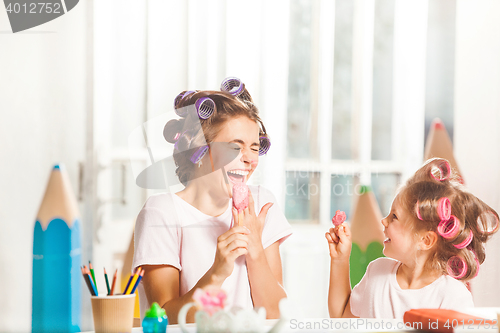 Image of Little girl sitting with her mother and eating ice cream