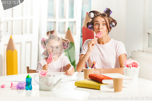 Image of Little girl sitting with her mother and eating ice cream