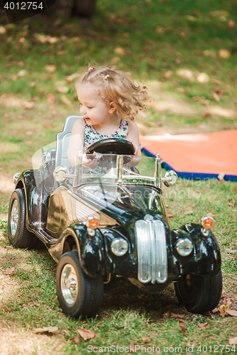 Image of The little baby girl playing at car