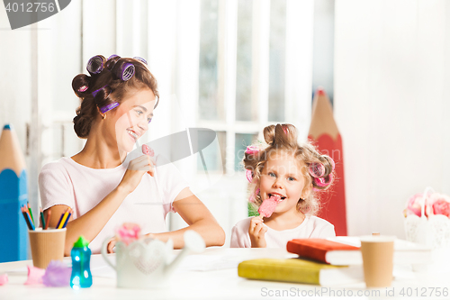 Image of Little girl sitting with her mother and eating ice cream