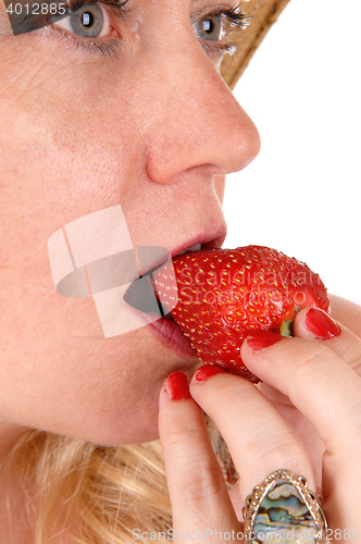 Image of Closeup woman eating strawberry.