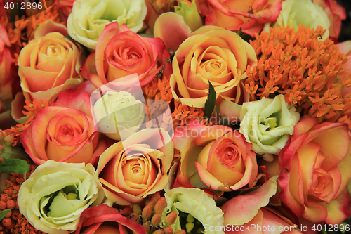 Image of Orange and yellow roses in a bridal bouquet