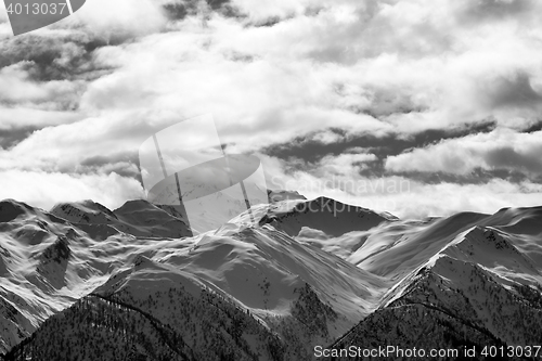 Image of Black and white view on snowy mountains and cloudy sky at evenin