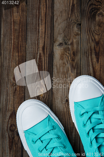 Image of blue sneakers on wooden surface