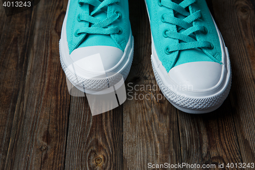 Image of blue shoes over empty wooden floor