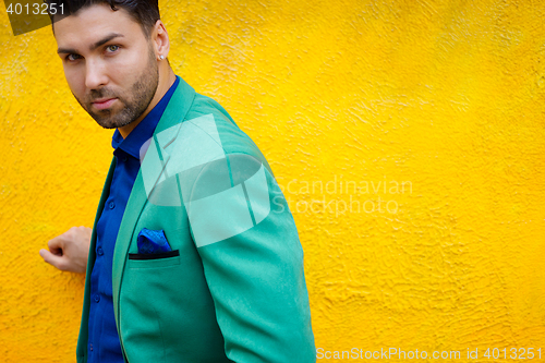 Image of Fashionable brunette guy posing on background of yellow wall