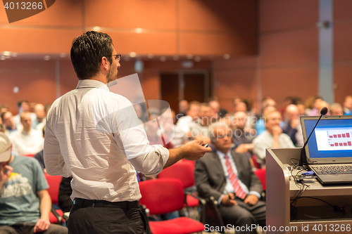 Image of Public speaker giving talk at Business Event.