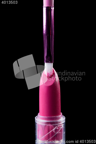 Image of Tube of lipstick with a brush make-up on black 