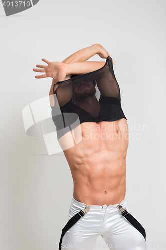 Image of Muscular sexy man taking off t shirt. Sexy stripper undressing.