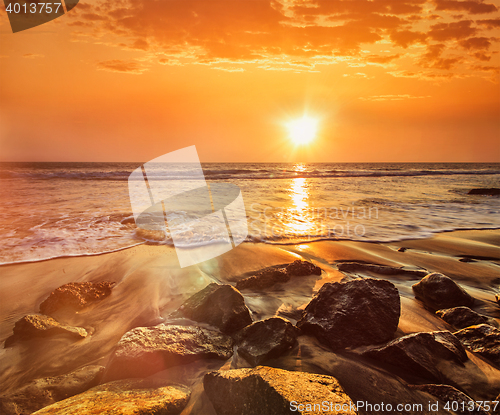 Image of Waves and rocks on beach of sunset