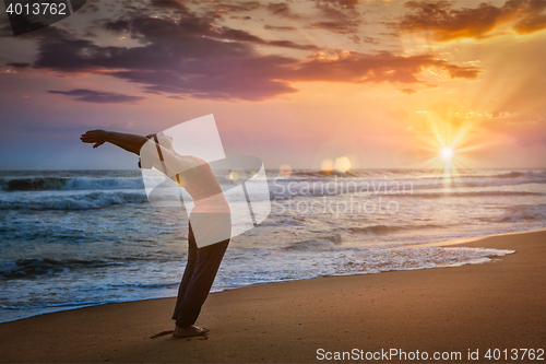 Image of Young sporty fit man doing yoga Sun salutation Surya Namaskar