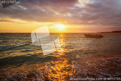 Image of Calm ocean with boat on sunrise