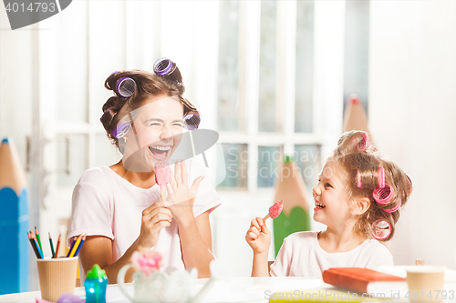 Image of Little girl sitting with her mother and eating ice cream