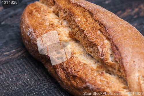 Image of Rustic bread on wood table. Dark moody background with free text space.