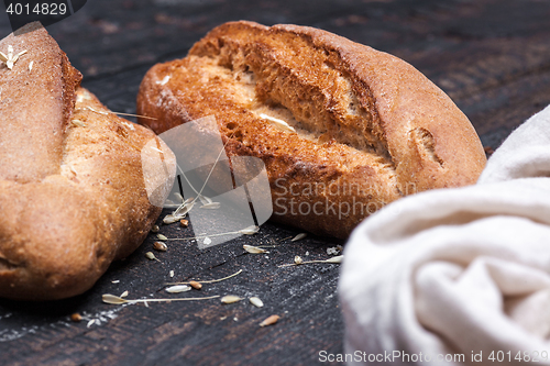 Image of Rustic bread on wood table. Dark moody background with free text space.