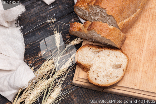 Image of Rustic bread on wood table. Dark wooden background