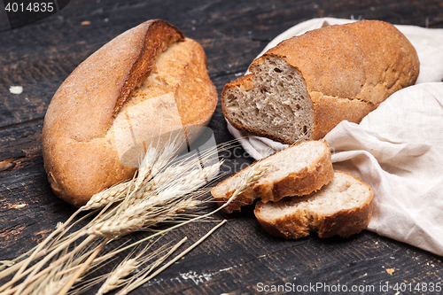 Image of Rustic bread on wood table. Dark wooden background