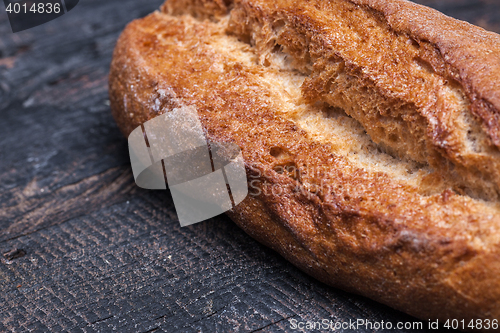 Image of Rustic bread on wood table. Dark moody background with free text space.