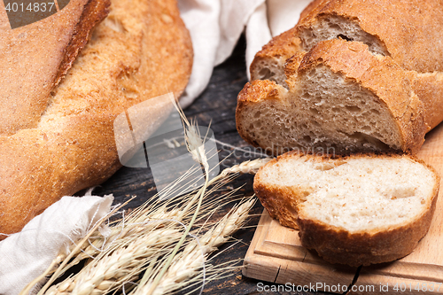 Image of Rustic bread on wood table. Dark wooden background