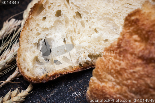 Image of Rustic bread on wood table. Dark wooden background