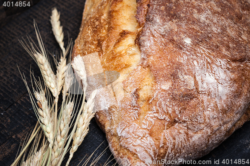 Image of Rustic bread on wood table. Dark wooden background