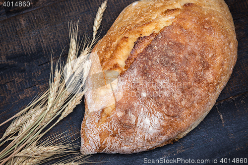 Image of Rustic bread on wood table. Dark moody background with free text space.